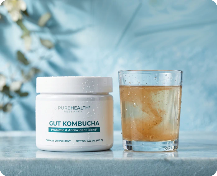 Gut Kombucha jar beside a glass of kombucha